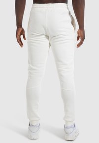 Weiße Jogginghose mit strukturiertem Finish und elastischem Bund. Mit seitlichen Reißverschlusstaschen und schmal zulaufenden Bündchen.