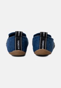 Niebieskie filcowe klapki typu slip-on z czarnym paskiem z logo na pięcie i teksturowaną gumową podeszwą. Prosty, zaokrąglony kształt bez zdobień.