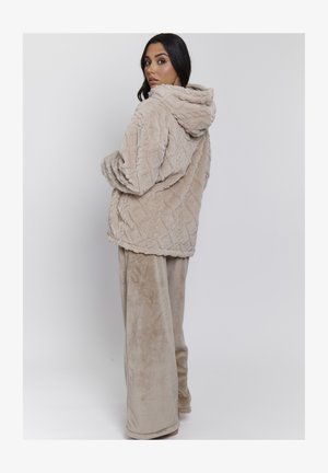 Beige, zachte hoodie met een gestructureerd patroon, voorzien van een capuchon en een relaxte pasvorm. Gecombineerd met bijpassende zachte, wijd-uitlopende broek.