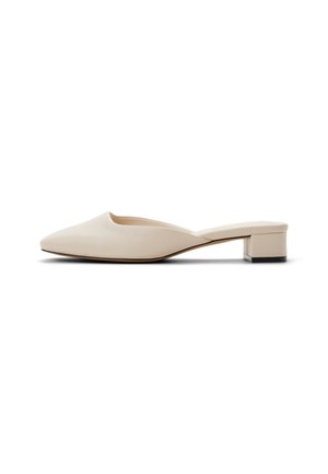 Beige leather mules with a pointed toe, low block heel, and smooth texture. Features an open back design and minimalistic aesthetic.