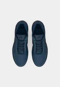 Jūras zila pāra Nike SB Zoom PS8 kedas ar auklām, skatītas no augšas uz balta fona.