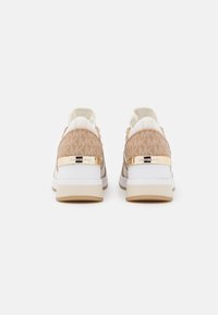 Sneaker beige e bianche con tomaia in suede a motivi, accenti metallici e suola in gomma. Vista posteriore che mostra il dettaglio del logo sul tallone.