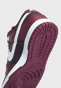 Nike tenisky s vrchní částí z koženého materiálu v barvě temně vínové a tmavě modré, s bílými akcenty a texturovanou maroon gumovou podrážkou s vzorovaným dezénem.