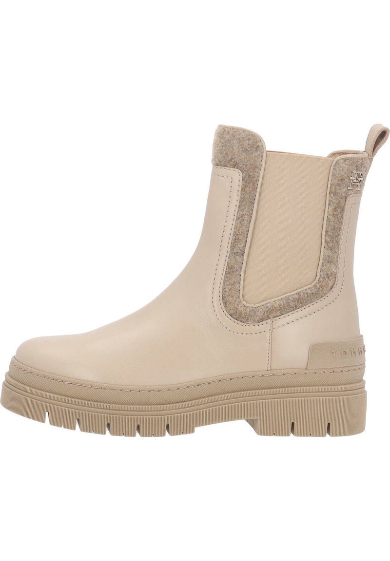 Botines beige de cuero con un suave acento de fieltro, que cuentan con una suela texturizada y paneles laterales elásticos para facilitar el uso.