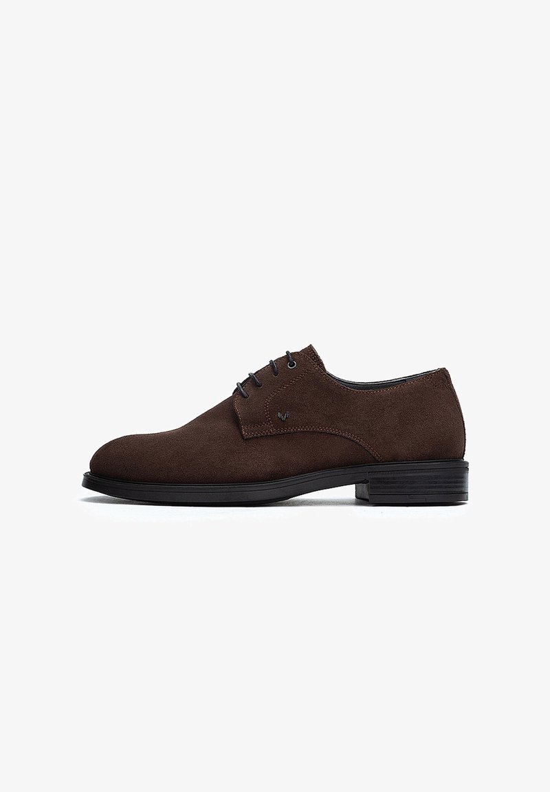 Zapato de vestir de ante marrón con una silueta elegante, puntera redonda y cordones negros. Presenta una parte superior texturizada y una suela de goma de perfil bajo.