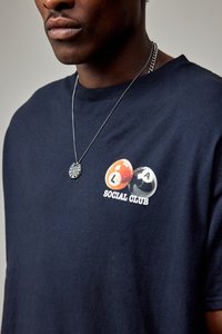 Tengerészkék pamut póló, narancssárga és fekete biliárdgolyókkal és "SOCIAL CLUB" felirattal, kerek nyakkal és rövid ujjal.