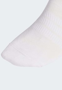 Bijela gležnjača s glatkom teksturom, ojačanim prstima i rebrastim rubom. Lagani materijal sa suptilnim sjajem, dizajniran za udobnost i prilagodbu.