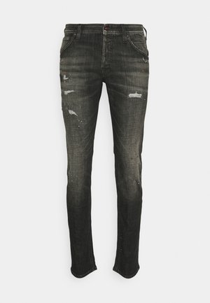 Jean noir slim avec détails usés et éclaboussures de peinture subtiles, style classique à cinq poches avec fermeture par bouton et fermeture éclair.