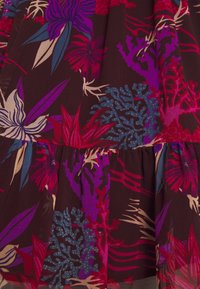 Bloemrijk jurkje met een donkerbruine achtergrond, voorzien van levendige paarse, roze en blauwe botanische patronen en een gelaagd ruches ontwerp.