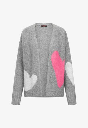 Grijze, openvallende gebreide cardigan met grote witte harten op de mouwen en een felroze hart aan de voorkant aan de rechterkant.
