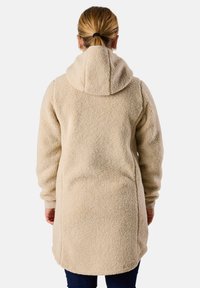 Beige katoenen lange jas met capuchon, gemaakt van een fluffy, gestructureerd materiaal. Beschikt over een gebogen zoom en lange mouwen, geschikt voor casual gebruik.