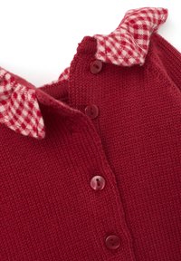Gilet en tricot rouge avec un col en tissu à carreaux, cinq boutons assortis et un motif de tricot texturé.