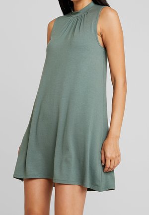 Sukienka bez rękawów w stonowanym zielonym kolorze, wykonana z miękkiego materiału, z okrągłym dekoltem i subtelnym marszczeniem z przodu.