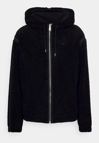Schwarze zip-up Kapuzenjacke aus weichem, strukturiertem Fleece. Mit Kapuze, Vordertaschen und kontrastierenden schwarzen Seitenstreifen. Silberner Reißverschluss.