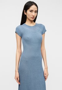 Φωτεινό γαλάζιο φόρεμα με ριμπ ύφασμα, εφαρμοστή σιλουέτα, κοντά μανίκια και στρογγυλή λαιμόκοψη, κατασκευασμένο από μαλακό, ελαστικό ύφασμα.