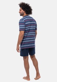 Raidallinen t-paita tummansinisessä, sinisessä ja punaisessa, lyhythihaisilla ja pyöreällä pääntiellä, yhdistettynä tummansinisiin shortsit. Kevyt kangas, rento muotoilu.