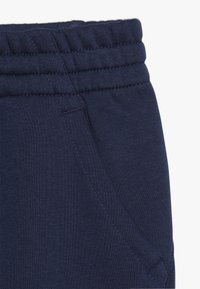 Mörkblå sweatpants med elastisk midja, sidoficka och mjukt material för maximal komfort. Stickade detaljer förstärker hållbarheten.