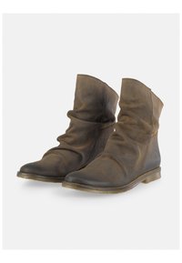 Botines de piel marrón con un diseño holgado, punta redonda y suela plana. Acabado texturizado y acentos de hardware mínimos.