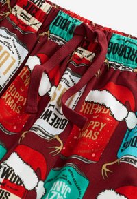 Maroon pajama shorts with festive graphics, featuring beer cans and Santa hats, elastic waistband with a drawstring, and a soft texture.