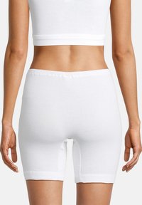 Weiße Baumwollshorts mit enganliegendem Schnitt, oberschenkellang und einem elastischen Bund. Sie haben eine glatte Textur und keine sichtbaren Nähte.