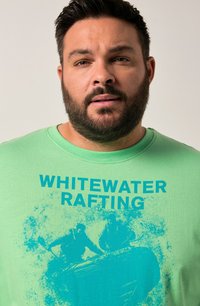 Green cotton t-shirt featuring a blue graphic print of rafting figures with the text "WHITEWATER RAFTING." Round neck and short sleeves.