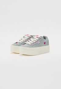 Denim platform tenisice svijetloplave boje s bijelim vezicama. Sadrže ružičaste akcentne detalje u obliku srca i teksturiranu bijelu gumenu podlogu.