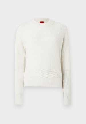 Biały dziany sweter z długimi rękawami, okrągłym dekoltem, teksturowanymi wzorami oraz lekko luźnym krojem. Czerwona metka marki widoczna na szyi.