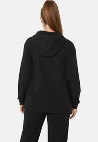 Black hooded sweatshirt made of soft fabric, featuring a relaxed fit, ribbed cuffs, and a kangaroo pocket.