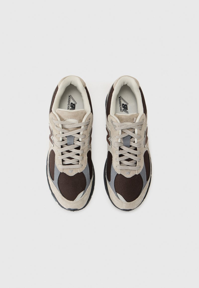 Sneakers featuring a mix of brown mesh and beige suede, with grey accents and laces. Rounded toe and textured rubber sole.