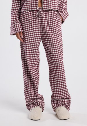 Ensemble de pyjama à carreaux en Bourgogne et blanc. Tissu doux, coupe décontractée, taille élastique avec cordon de serrage. Associé à des chaussons pelucheux de couleur crème.
