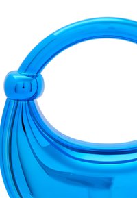 Áttetsző kék kézitáska ívelt fogantyúval és lekerekített részletekkel. Sima felület, fényes kivitel és modern, letisztult dizájn.