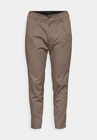 Pantalones marrones a medida con una textura suave, que presentan un cierre de botón en la parte delantera, pasadores para cinturón y dos bolsillos laterales.