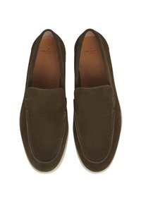 Mocasini din suede maro, stil loafers, cu o textură netedă, cusături subtile și o talpă din cauciuc albă. Interiorul are o tălpică de nuanță bej.