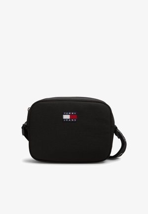 Sort rektangulær crossbody taske med Tommy Jeans-logo og justerbar rem på hvid baggrund.