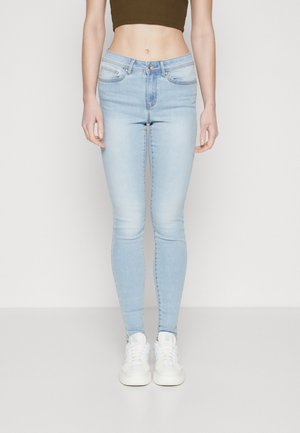 Light blue skinny jeans with a high waist, featuring front pockets, subtle fading details, and a slim fit down to the ankles.