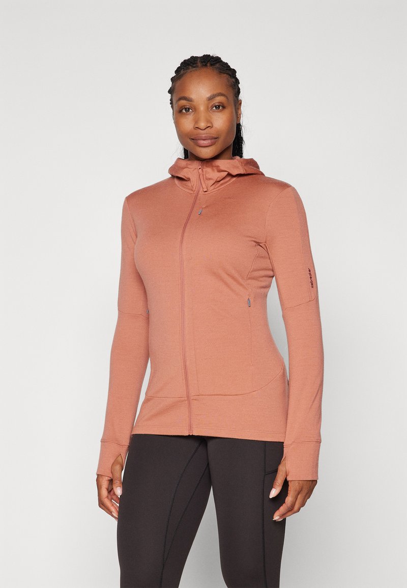 Hoodie leve, com fecho zip, na cor rosa velho, apresentando colarinho alto, mangas longas e buracos para os polegares. Tecido suave e elástico com costuras mínimas.