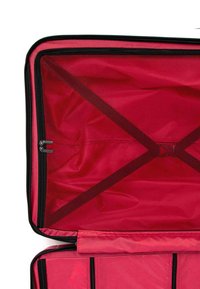 Vnitřek červeného kufru se hladkou texturou, vybavený síťovou kapsou na zip a nastavitelnými křížovými popruhy pro zabezpečení obsahu.