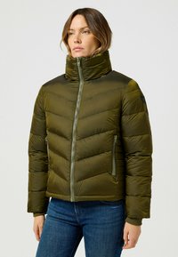 Oliwkowa, ocieplana kurtka puff z wysokim kołnierzem, w chevronowe przeszycia i dwoma zamykanymi na zamek bocznymi kieszeniami, cechująca się smukłym designem.