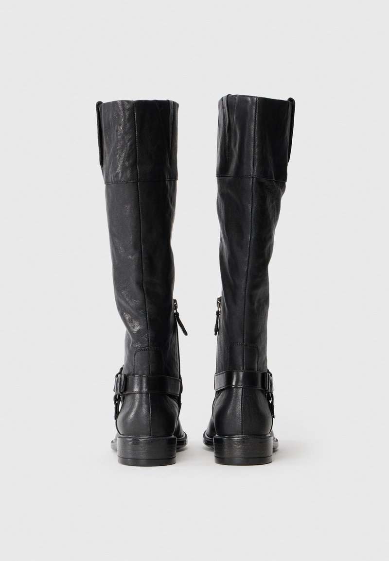 Schwarze Lederknielange Stiefel mit gewölbtem Schaft, seitlichen Reißverschlüssen, Schnallenakzenten und flacher Sohle. Glatte Textur und figurbetontes Design.