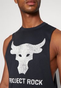 Mustat hihattomat paidat, joissa on suuri valkoinen halkeillut häränpääkuva ja teksti "PROJECT ROCK" alla. Valmistettu pehmeästä puuvillasta.