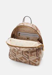 Hnědý batoh se vzorem a zlatým zipem; vnitřek má béžovou podšívku s logy, kapsu na zip a kontrastní krémové detaily.