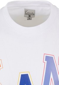 White cotton t-shirt featuring large, colorful graphic letters "KAN" in orange, yellow, blue, and pink; round neckline; label visible.
