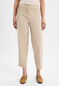 Beige cargobroek met voor- en zijzakken, gemaakt van lichtgewicht stof. Verkorte stijl met een relaxte pasvorm en een subtiele textuur.