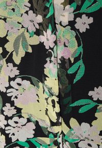 Blusa com padrão floral em preto com flores verdes, amarelas e rosas. Apresenta botões pretos e um tecido macio e texturizado.