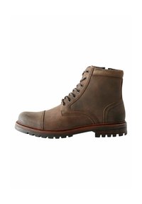 Botas de cuero marrón hasta el tobillo con punta redondeada, cuello acolchado, cordones con seis ojales y suela de goma texturizada. Acentos de costura en los laterales.