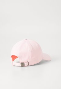 Roze honkbalpet met een gebogen klep en een verstelbare band met een metalen gesp en een zachte stofstructuur. De binnenkant is in een helder oranje kleur.