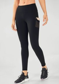 Black leggings made of stretchy material with a high waistband and a side pocket. They have a smooth texture and are fitted from waist to ankle.