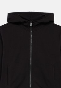 Črna kapa s patentnim zadrgo, kapuco z oblogo, dvema sprednjima žepoma ter zadrgo po celotni dolžini. Gladek tekstilen material brez vidnih vzorcev.