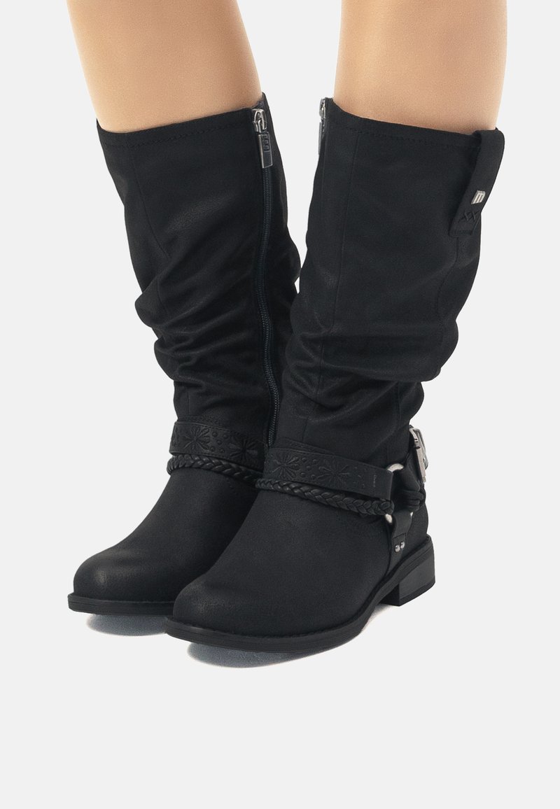 Botas negras hasta la rodilla, hechas de un tejido suave, con una correa trenzada, detalles en metal plateado y un tacón bajo cuadrado. Cierre con cremallera.