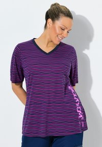 Camiseta de rayas moradas y azul marino con escote en V, manga corta y un detalle gráfico rosa en el costado. Tejido suave con un ajuste holgado.